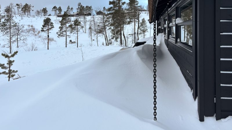 Fjern snø som ligger inntil hytteveggen